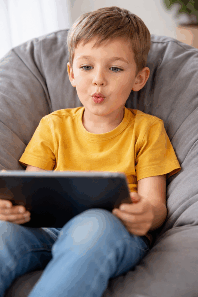 A young boy practising his speech sounds from home via telehealth