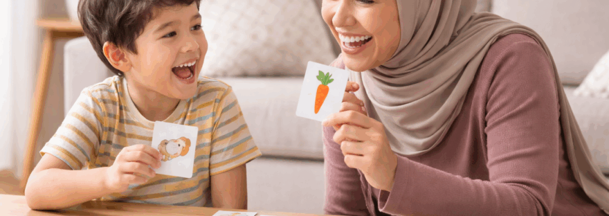 A mother and son play a card game to practice his speech sounds in therapy
